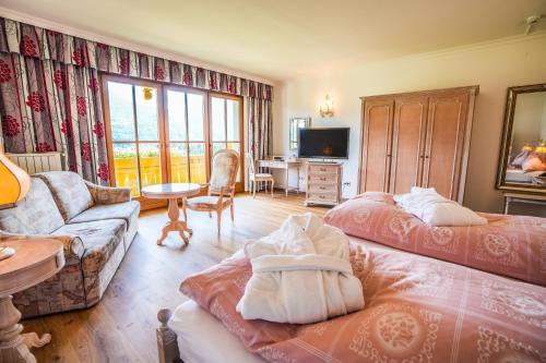 a living room with two beds and a couch at Hotel Glocknerhof in Berg im Drautal
