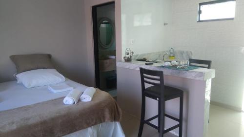 a bedroom with a bed and a sink and a stool at Barcel Flat in Teresina