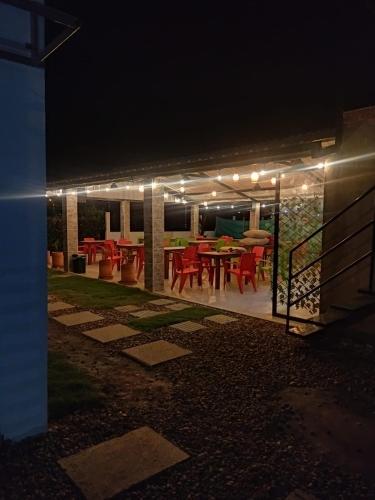 a patio with a table and chairs at night at Chiriguare parrilla in Villavicencio