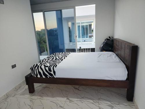 Ce lit se trouve dans un dortoir doté d'une couverture zébrée. dans l'établissement Chiriguare parrilla, à Villavicencio
