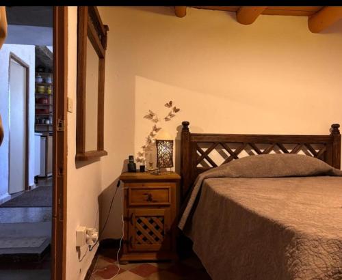 1 dormitorio con 1 cama y 1 mesa con mesita de noche en La casita en la Alcornocosa -Sevilla, en Sevilla