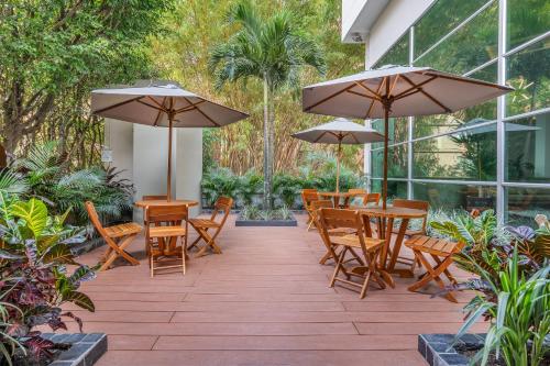 a patio with tables and chairs and umbrellas at Novelty Suites Hotel in Medellín