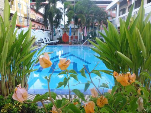 a large swimming pool with orange flowers in front of it at Villa Oranje Pattaya in Pattaya Central