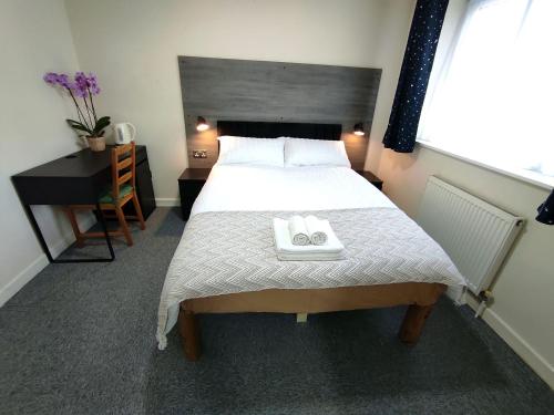 a bedroom with a bed with two towels on it at Osney Willow Studio Flat - Self Contained Studio Flat in Oxford