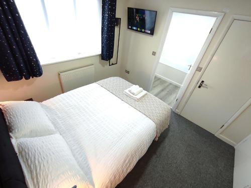 a bedroom with a white bed and a window at Osney Willow Studio Flat - Self Contained Studio Flat in Oxford
