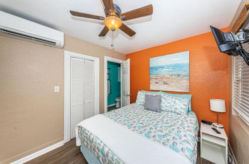 a bedroom with a bed and a ceiling fan at Sunset Beach Bungalow 3 in St. Pete Beach