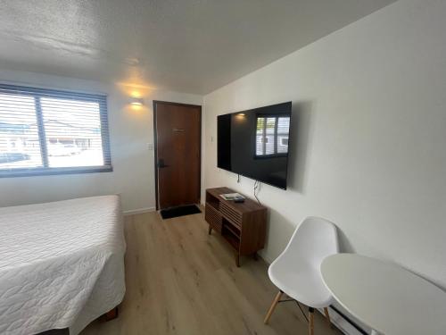 1 dormitorio con cama, mesa y TV en 1 Queen Bed en Lake City