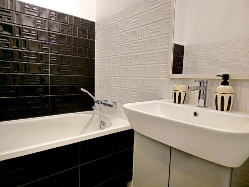 a bathroom with a white sink and a bath tub at Studio Pieskowa Skała in Warsaw