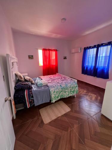 a bedroom with a bed and a red curtain at Villa avec jardin in Punta Cana