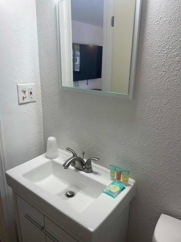 a white bathroom sink with a mirror and a toilet at 1 Queen Bed in Lake City