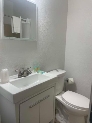 a white bathroom with a sink and a toilet at 1 Queen Bed in Lake City