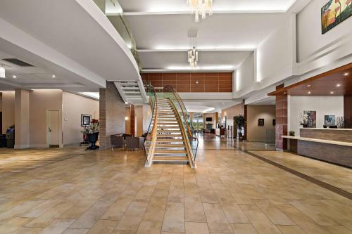 a lobby with a staircase in the middle of a building at Best Western Plus Orangeville Inn & Suites in Orangeville