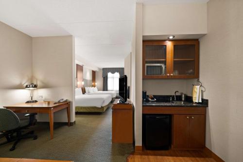 a hotel room with a kitchen and a bedroom at Best Western Plus Orangeville Inn & Suites in Orangeville