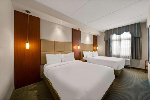 a hotel room with two beds and a window at Best Western Plus Orangeville Inn & Suites in Orangeville