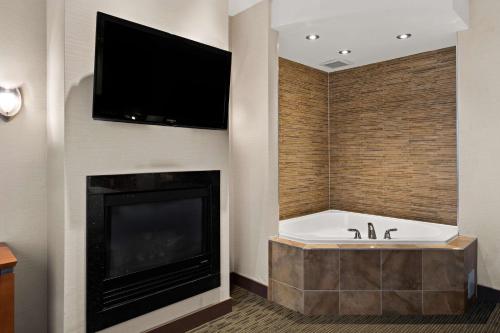 a bathroom with a tub and a tv and a fireplace at Best Western Plus Orangeville Inn & Suites in Orangeville