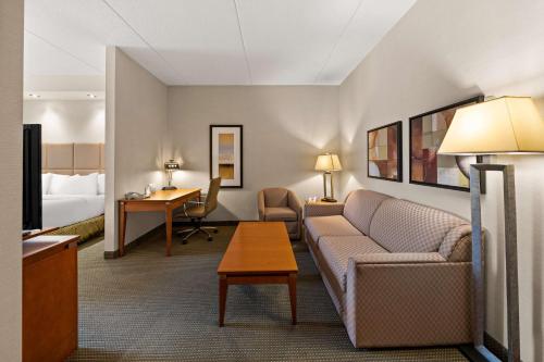 a hotel room with a couch and a bed at Best Western Plus Orangeville Inn & Suites in Orangeville