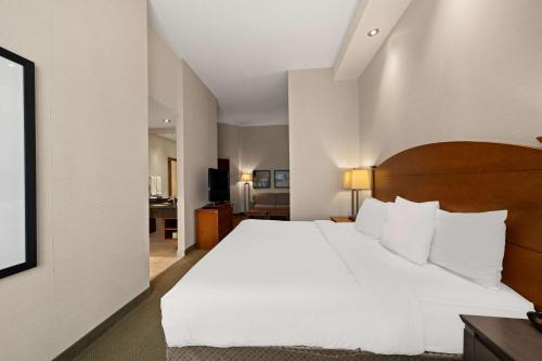 a bedroom with a large bed with white sheets and pillows at Best Western Plus Orangeville Inn & Suites in Orangeville