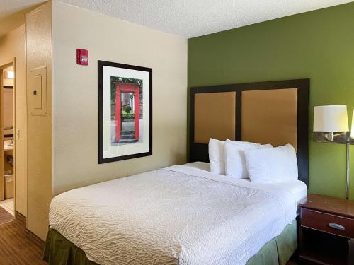 Habitación de hotel con cama grande con almohadas blancas en Motel 6 Columbus, GA Columbus Airport, en Columbus
