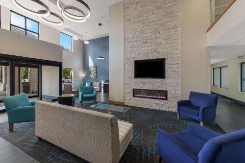 a living room with a couch and chairs and a fireplace at Comfort Inn & Suites Tipp City - I-75 in Tipp City