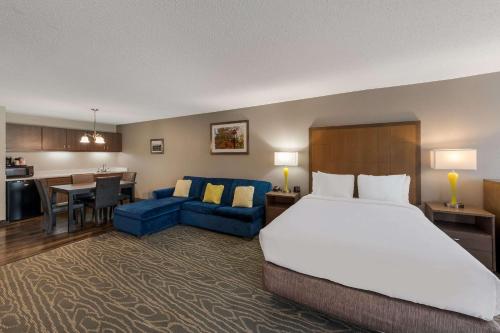 Tipp CityにあるComfort Inn & Suites Tipp City - I-75のベッドとリビングルームが備わるホテルルームです。