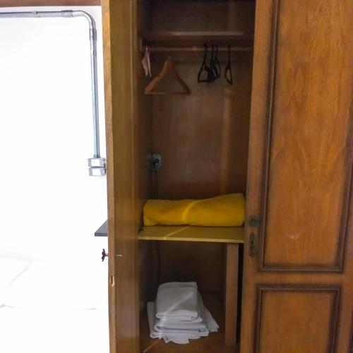 a closet with a yellow pillow on a shelf at Micasa Hostel - Congonhas in Sao Paulo