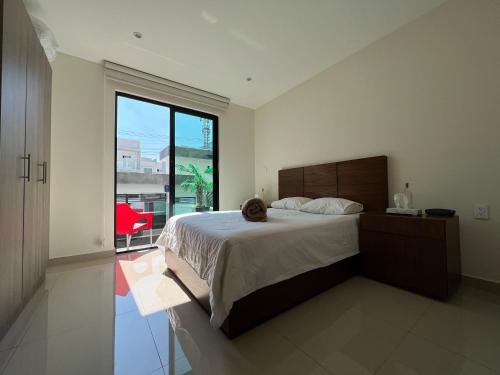 - une chambre avec un grand lit et une grande fenêtre dans l'établissement Departamento en CDMX, zona norte, à Mexico