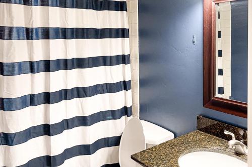 a bathroom with a shower curtain and a toilet at Alpine Escape in Edwards