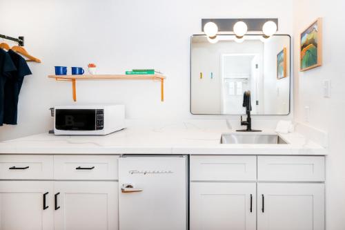 uma cozinha branca com um lavatório e um espelho em Anacortes Inn em Anacortes