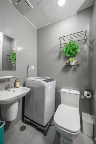 a bathroom with a white toilet and a sink at Newly Turned 0ver Cond0- Air Makati 1BR with Balcony in Manila