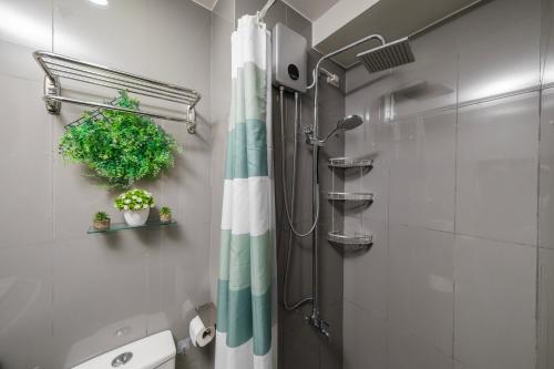 a bathroom with a shower with a green and white shower curtain at Newly Turned 0ver Cond0- Air Makati 1BR with Balcony in Manila