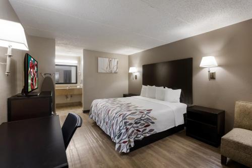 una camera d'albergo con letto e sedia di Red Roof Inn Atlanta Airport NE Conley a Conley