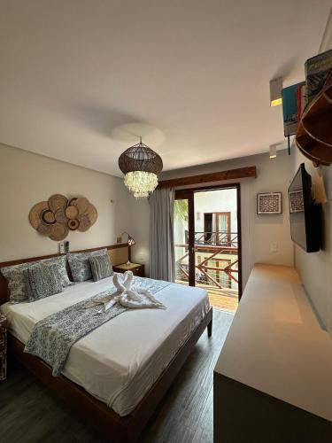 Un dormitorio con una cama grande y un balcón. en Reserva BG - Praiano - Vista mar, en Barra Grande