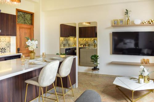 cocina con barra con sillas blancas y TV en Modern luxury Studio with Rooftop + parking, en Panamá