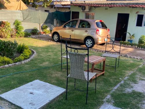 a yard with chairs and a car parked in a driveway at Aeropark Residencial (B&B) in Maputo