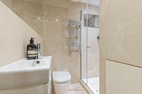 a bathroom with a toilet and a sink and a shower at Trafalgar Square Arty Apartment in London