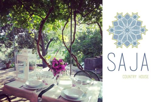 a table with plates and glasses and flowers on it at Saja Country House in Acireale