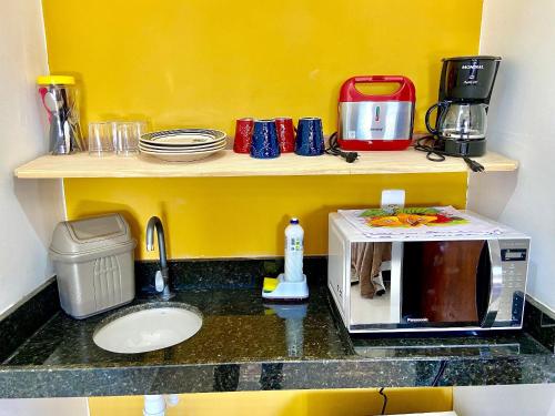 una cucina con piano di lavoro e forno a microonde di Villa Madu Milagres a 300 metri dalla spiaggia a São Miguel dos Milagres