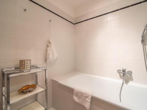 ein weißes Badezimmer mit einer Badewanne und einem Waschbecken in der Unterkunft Landhaus Leitzinger OG1 in St. Wolfgang