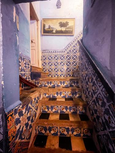 a staircase in a house with blue and white tiles at La Maison Haute Larache Morocco in Larache