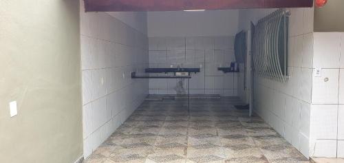 an empty bathroom with white tile walls and ailed floor at Casa Temporada Guriri Pôr do Sol in São Mateus