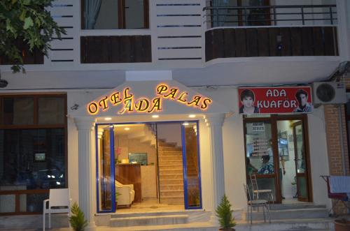 a restaurant with a neon sign in front of it at Ada Palas Otel in Marmara Adasi