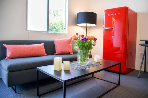 a living room with a couch and a table with flowers at Hollywood Guesthouse in Los Angeles