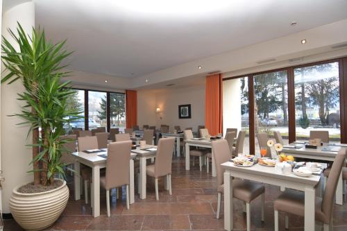 un restaurant avec des tables, des chaises et des plantes dans l'établissement Al Ponte Garnì, à Pergine Valsugana