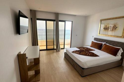 1 dormitorio con 1 cama y vistas al océano en Ocean Mirror Apartment en Praia