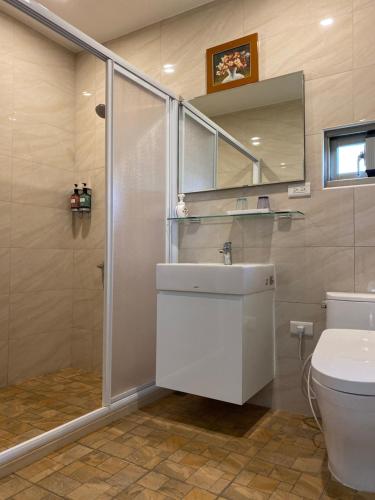 a bathroom with a shower and a sink and a toilet at Lily Garden Homestay in Yilan City