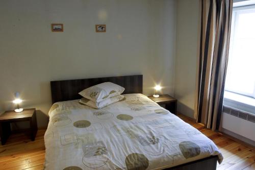 a bedroom with a bed with two tables and a window at Cēsu Namiņš in Cēsis