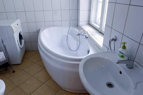 a bathroom with a sink and a tub next to a toilet at Cēsu Namiņš in Cēsis