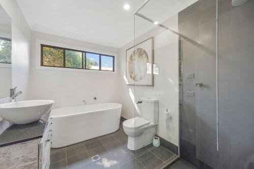 a bathroom with a tub and a toilet and a sink at Seascape in North Haven