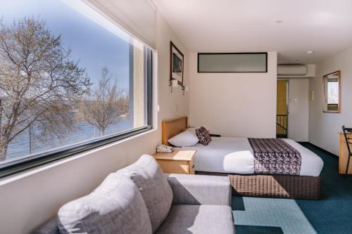 pokój hotelowy z łóżkiem i dużym oknem w obiekcie Motel 429 w mieście Hobart