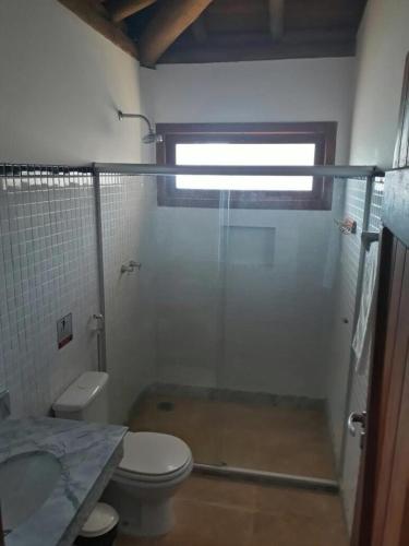 ein Bad mit einer Dusche, einem WC und einem Waschbecken in der Unterkunft POUSADA CANTINHO MÁGICO in Marau
